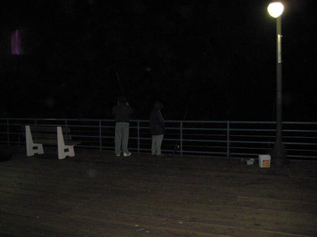 Two people fishing from Pier. These guys are dangerous for surfers.